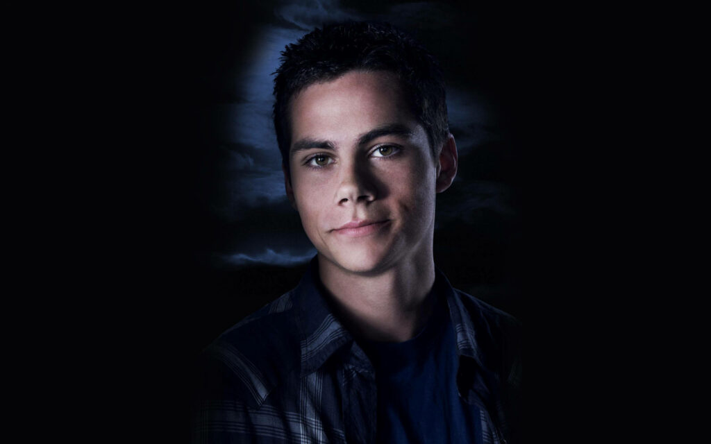 Young Dylan O'Brien portrait with moody blue tones soft lighting and casual relaxed style wallpaper