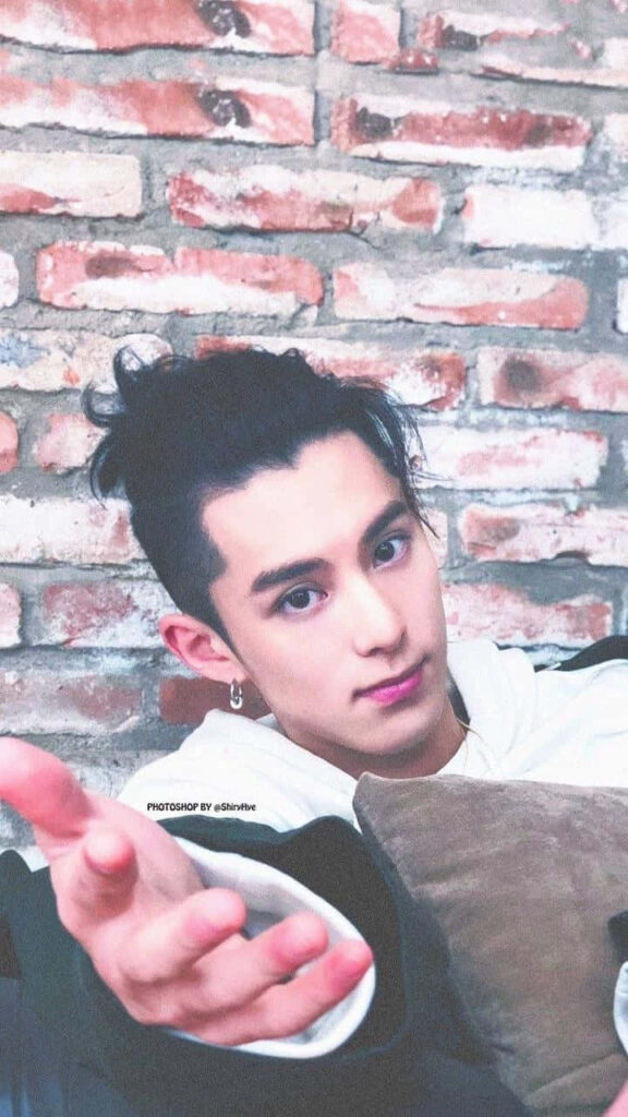 Dylan Wang relaxed pose arm extended rustic brick wall casual street style modern fashion Wallpaper