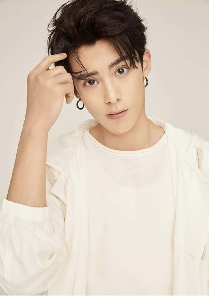 Dylan Wang in white shirt and light jacket on soft beige background minimalist elegant wallpaper