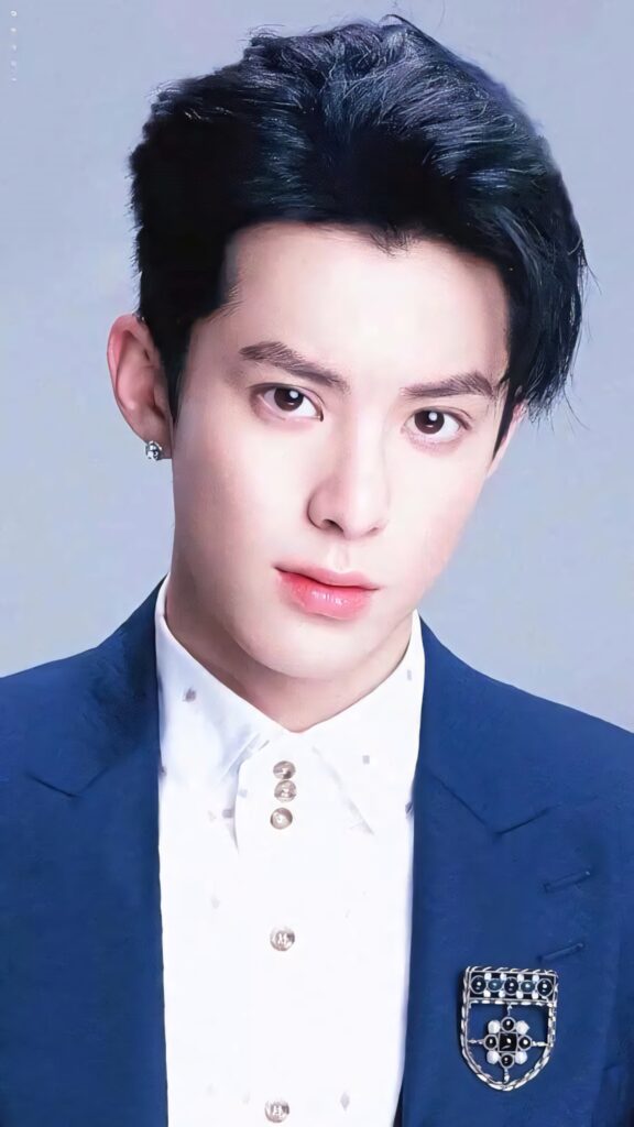 Dylan Wang in navy blazer school uniform white shirt metallic buttons soft blue background wallpaper