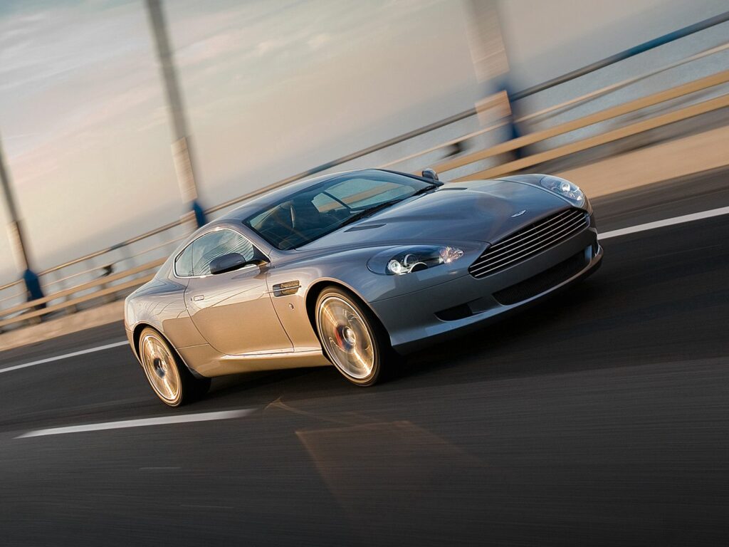 Dynamic Side View of Gray 2008 Aston Martin DB9 on Bridge Wallpaper