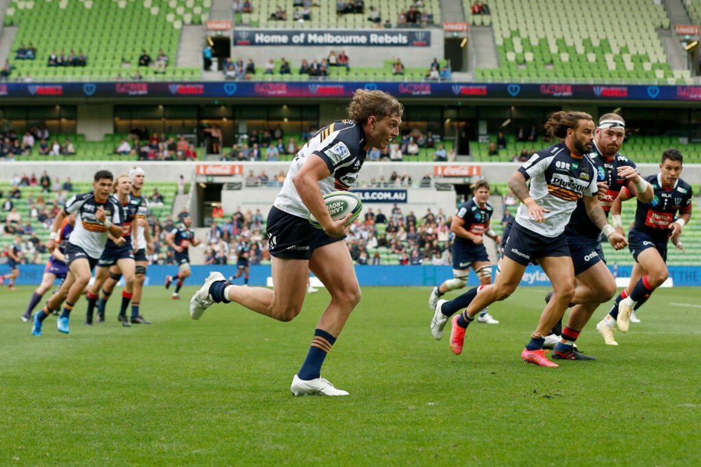 ACT Brumbies rugby players sprinting on green field showcasing teamwork athleticism wallpaper