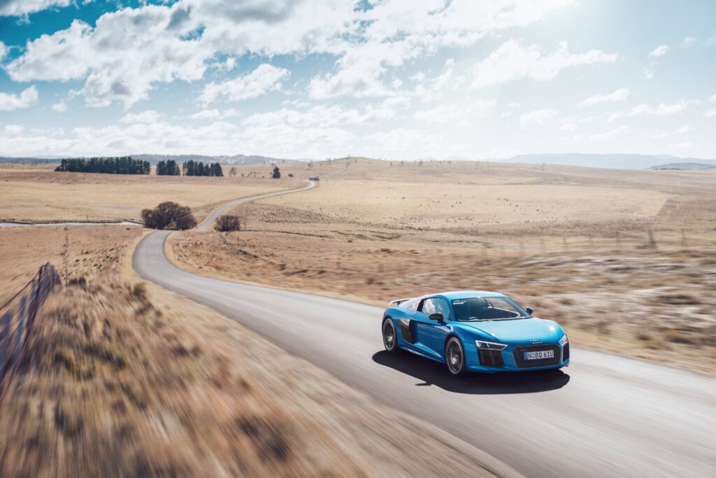 Audi R8 V10 Racing on Scenic Road: Freedom & Speed Wallpaper