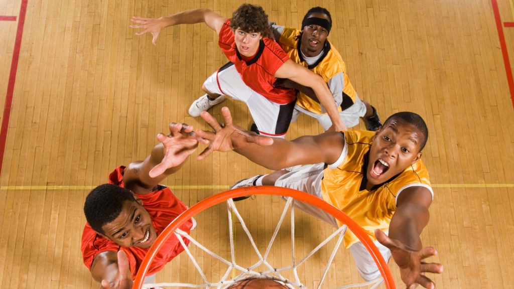 Top view intense basketball rebound action with players in red and yellow jerseys on court Wallpaper