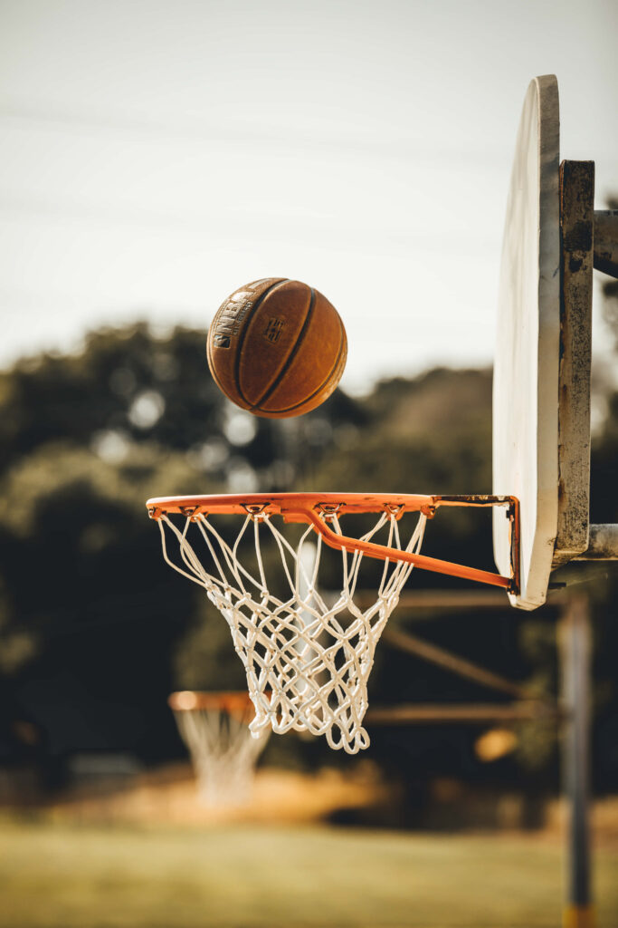 Dynamic Basketball Wallpaper: A Ball Soaring Toward a Classic Hoop