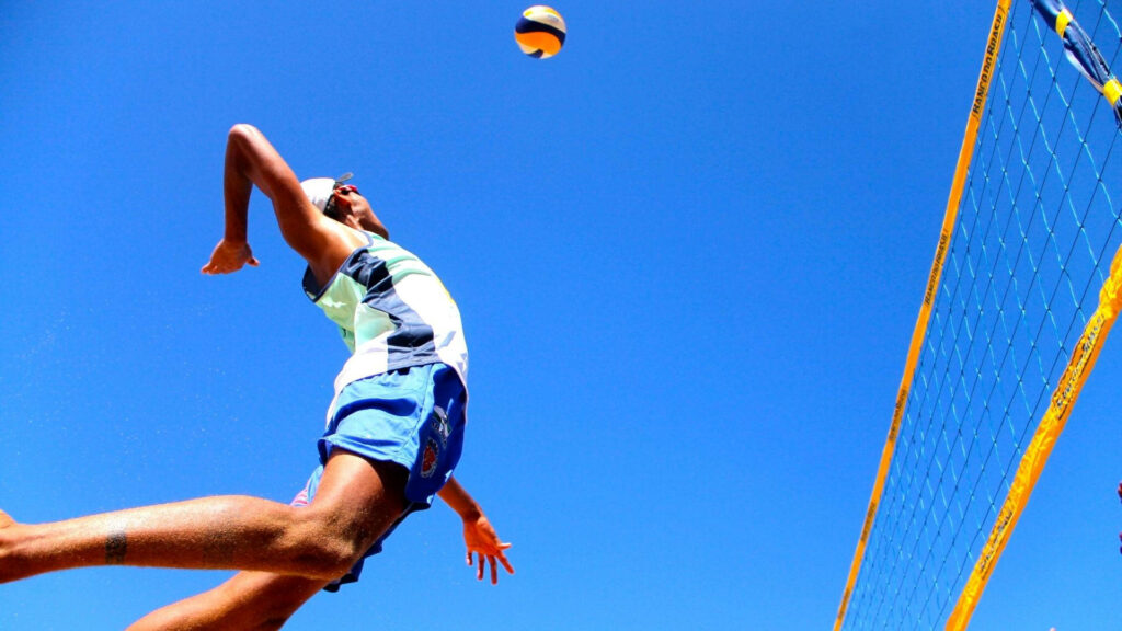 Dynamic Beach Volleyball Player Wallpaper: Sky-High Spike Background
