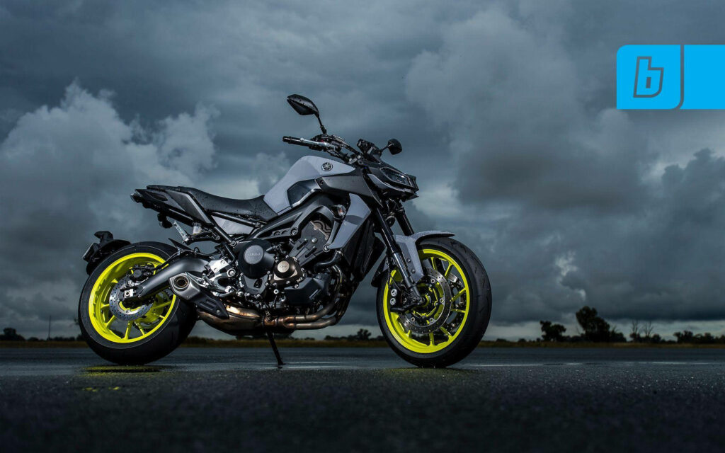 Dynamic Black Yamaha MT-15 Wallpaper with Yellow Rims & Cloudy Background