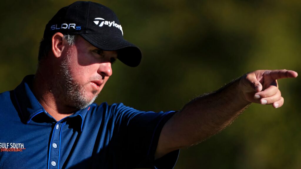 Boo Weekley focused pointing golf wallpaper with dark cap blue shirt green background golf fans