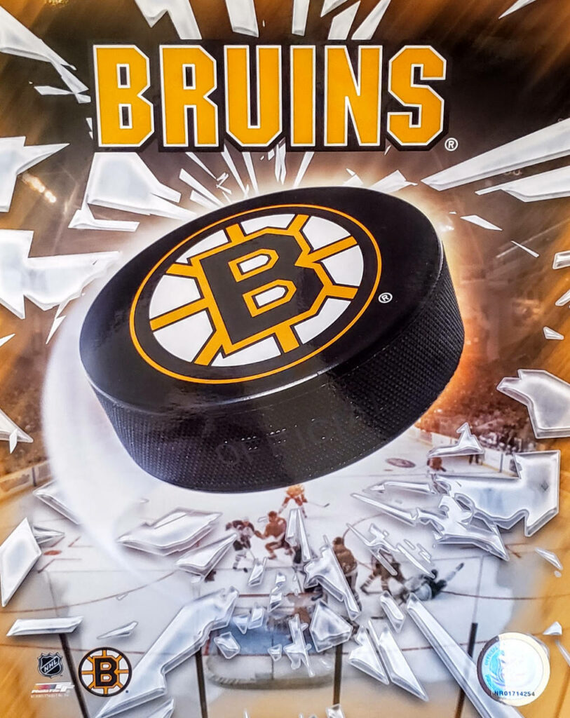 Boston Bruins logo hockey puck bursting through glass on vibrant ice rink background wallpaper