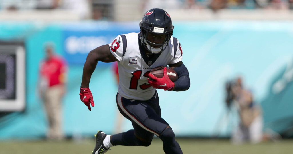Running Brandin Cooks in Houston Texans uniform sprinting on field vivid NFL football action wallpaper
