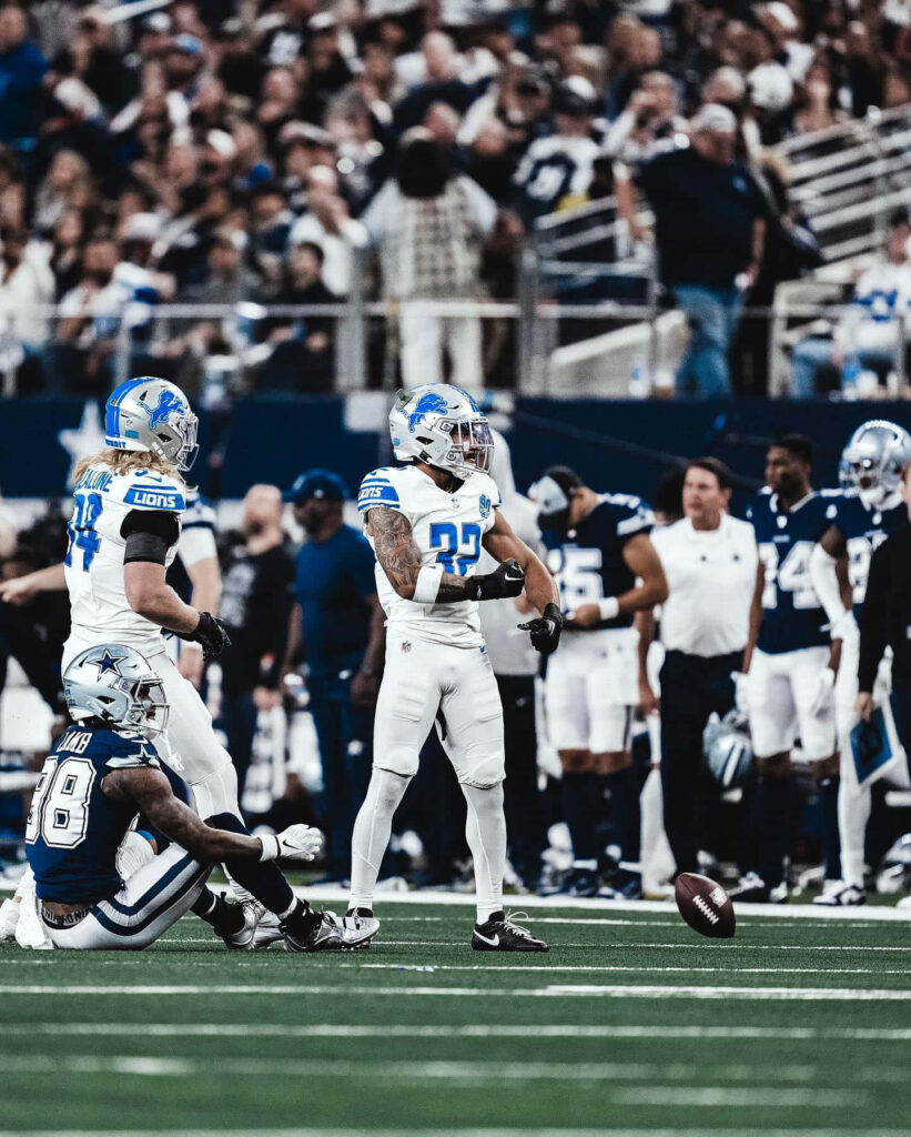 Brian Branch Detroit Lions safety in action NFL game vibrant colors energetic crowd wallpaper
