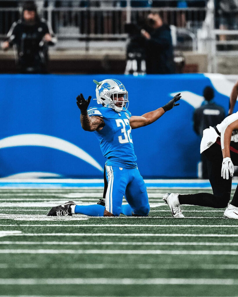 Brian Branch Detroit Lions in action blue uniform athletic pose NFL football wallpaper background