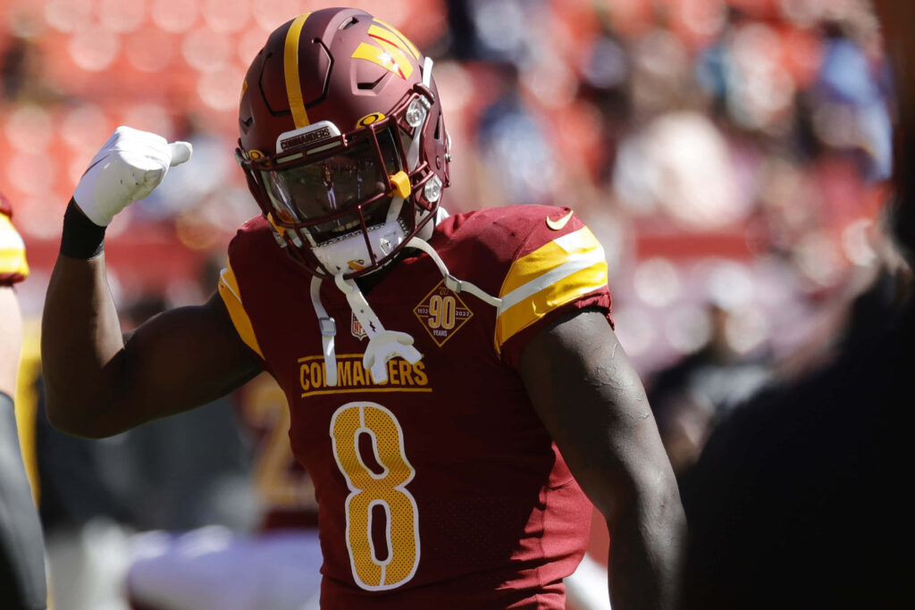 Brian Robinson Jr celebrating in full uniform vibrant burgundy gold Commanders football wallpaper