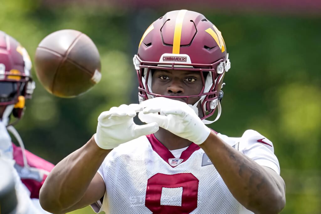 Brian Robinson Jr in Commanders uniform catching football during practice vibrant sports wallpaper