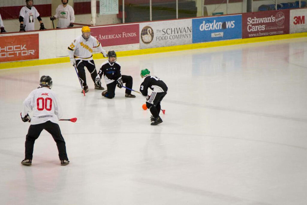 Dynamic Broomball Match on Ice: Intense Action Wallpaper Background