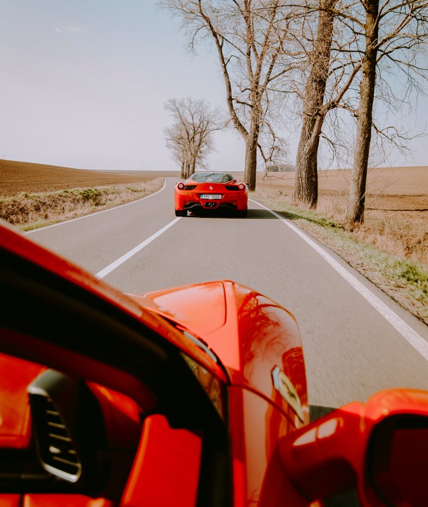 Thrilling Car Chase Wallpaper: Red Sports Cars on Open Road