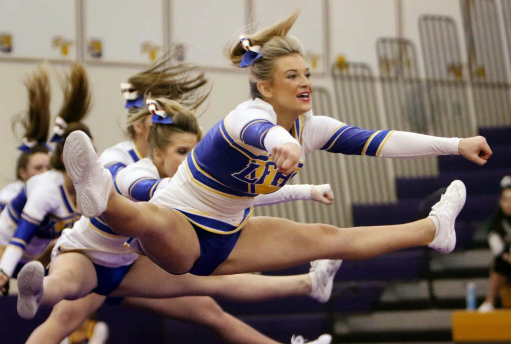 Dynamic Cheerleader Wallpaper: Strength, Energy & Precision in Action