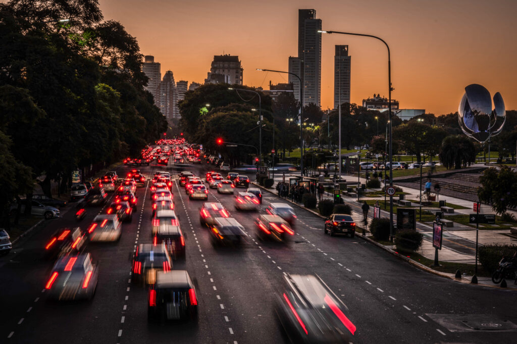 Dynamic City Evening Wallpaper: Cars, Lights, and Sunset Glow