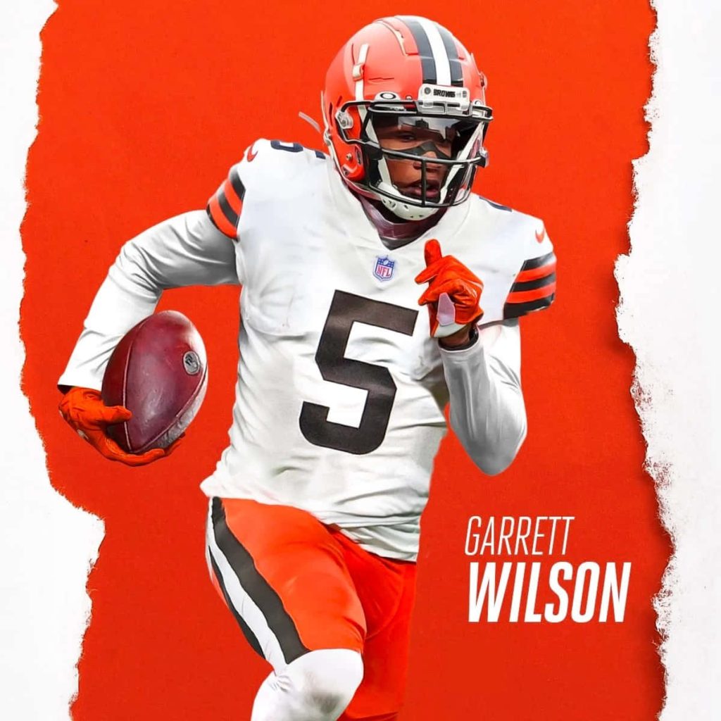 Cleveland Browns NFL player running with football on bold textured orange background wallpaper