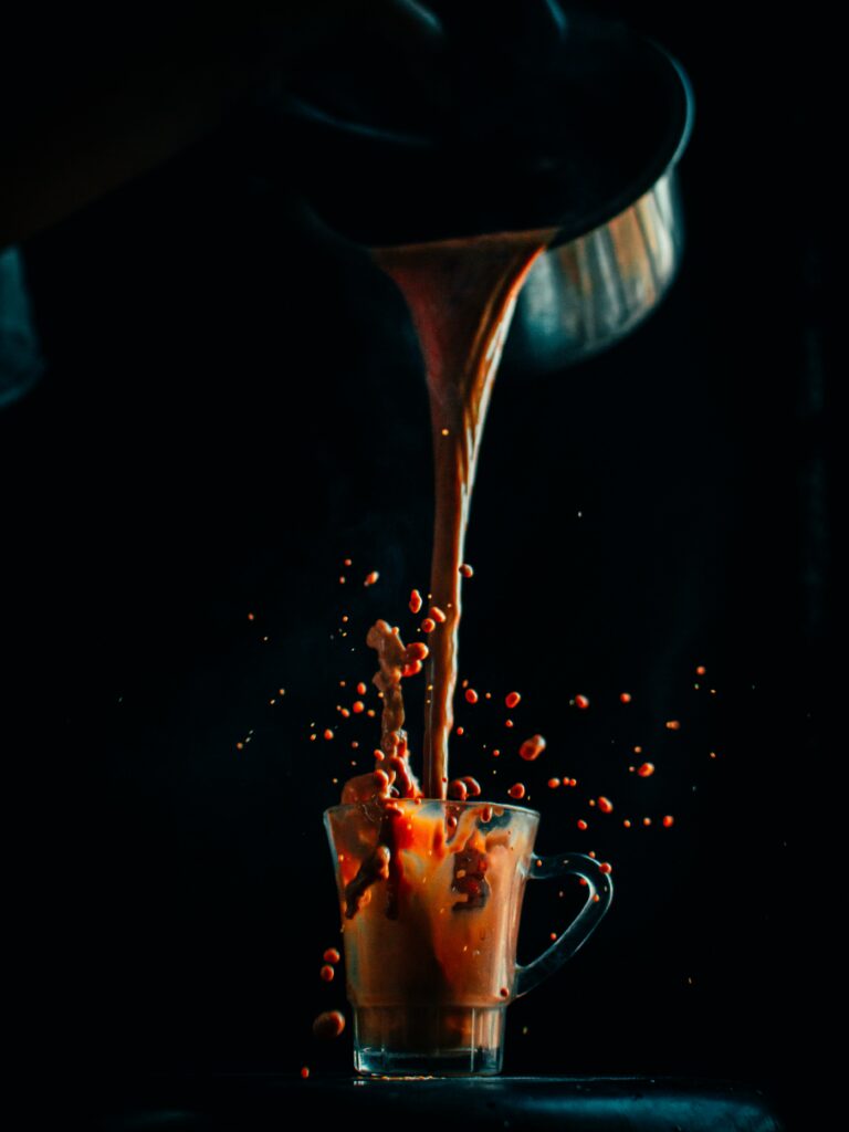 Dynamic Coffee Splash Wallpaper: Glass Cup Against Dark Background