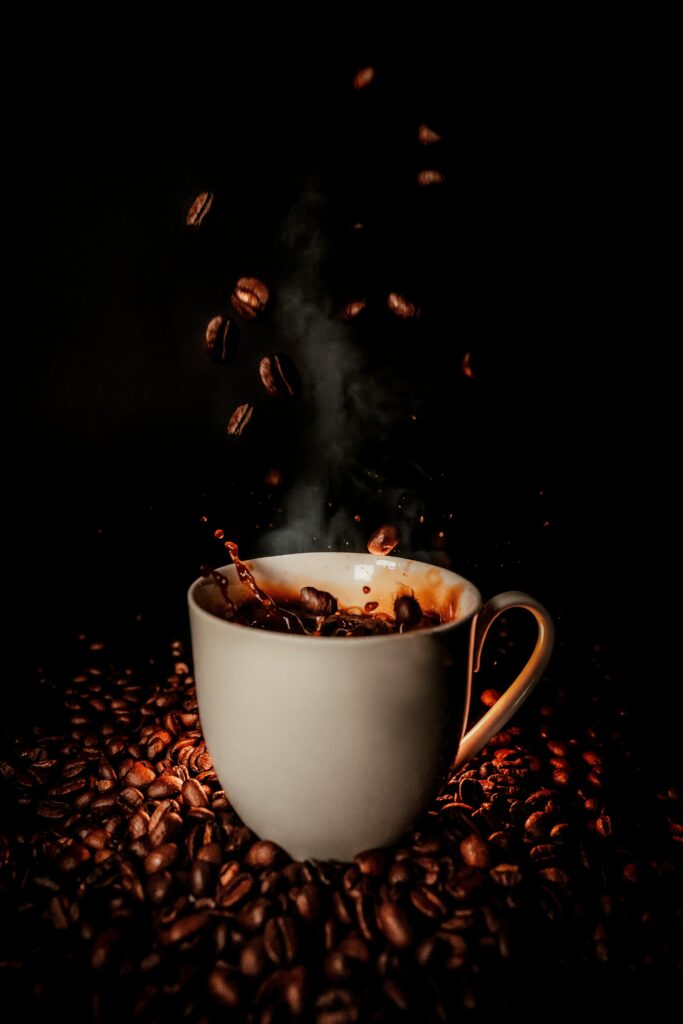 Dynamic Coffee Splash Wallpaper: Steaming Cup & Scattered Beans