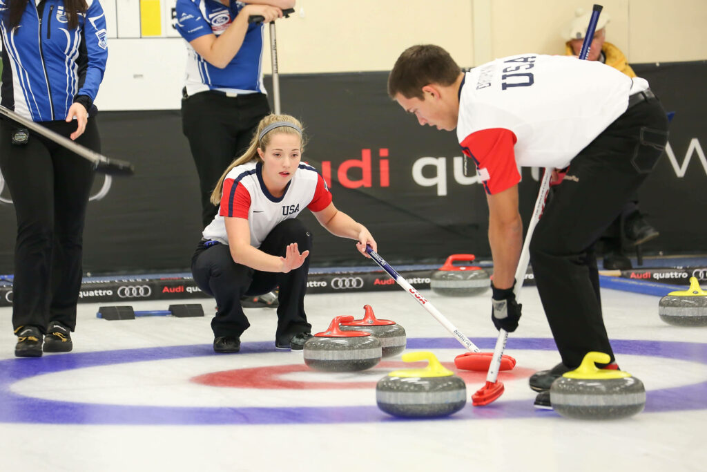 Dynamic Curling Match Wallpaper: Players in Action on Ice