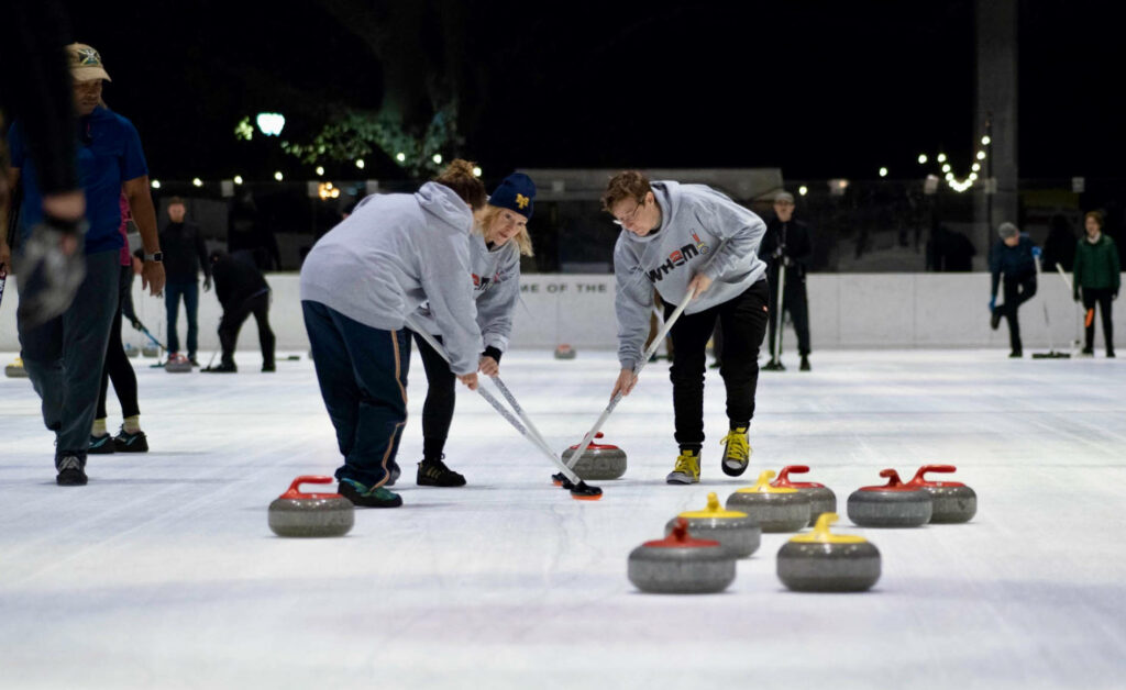 Dynamic Curling Team Wallpaper: Intense Ice Rink Practice Background