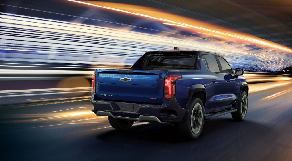 Deep blue Chevrolet Silverado RST speeding through tunnel with vibrant orange white motion blur streaks Wallpaper
