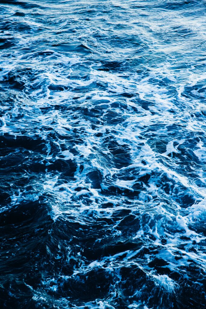 Dynamic deep blue ocean wallpaper with white-capped waves creating a refreshing natural scene