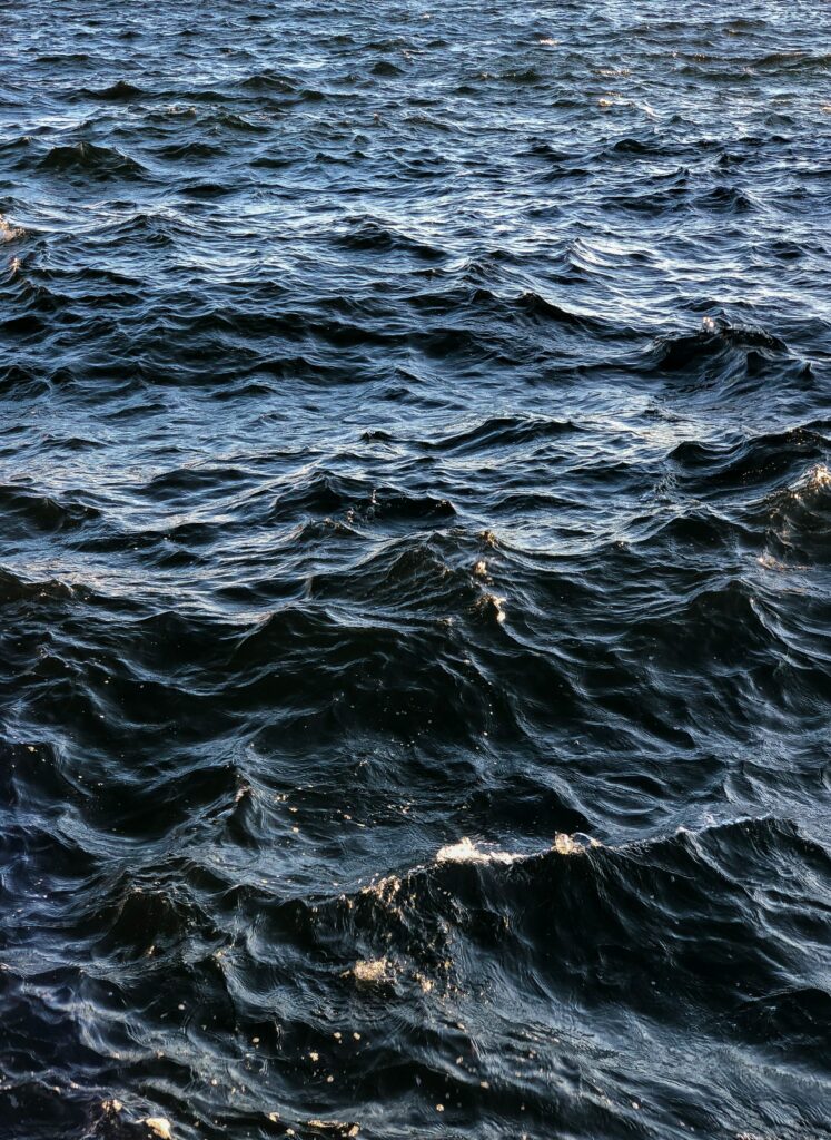 Dynamic deep blue ocean waves with detailed wavy patterns and natural water glare wallpaper