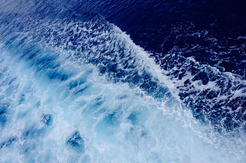 Dynamic deep blue ocean waves with foamy white water in a vibrant seascape wallpaper background