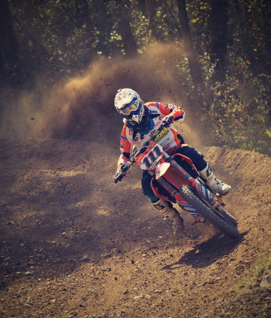 Vibrant Dirt Bike Rider Turn Wallpaper - Dusty Action Shot Background