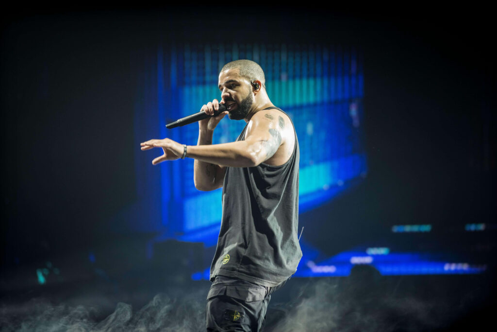 Drake's Energetic Stage Performance: Captivating Wallpaper Background