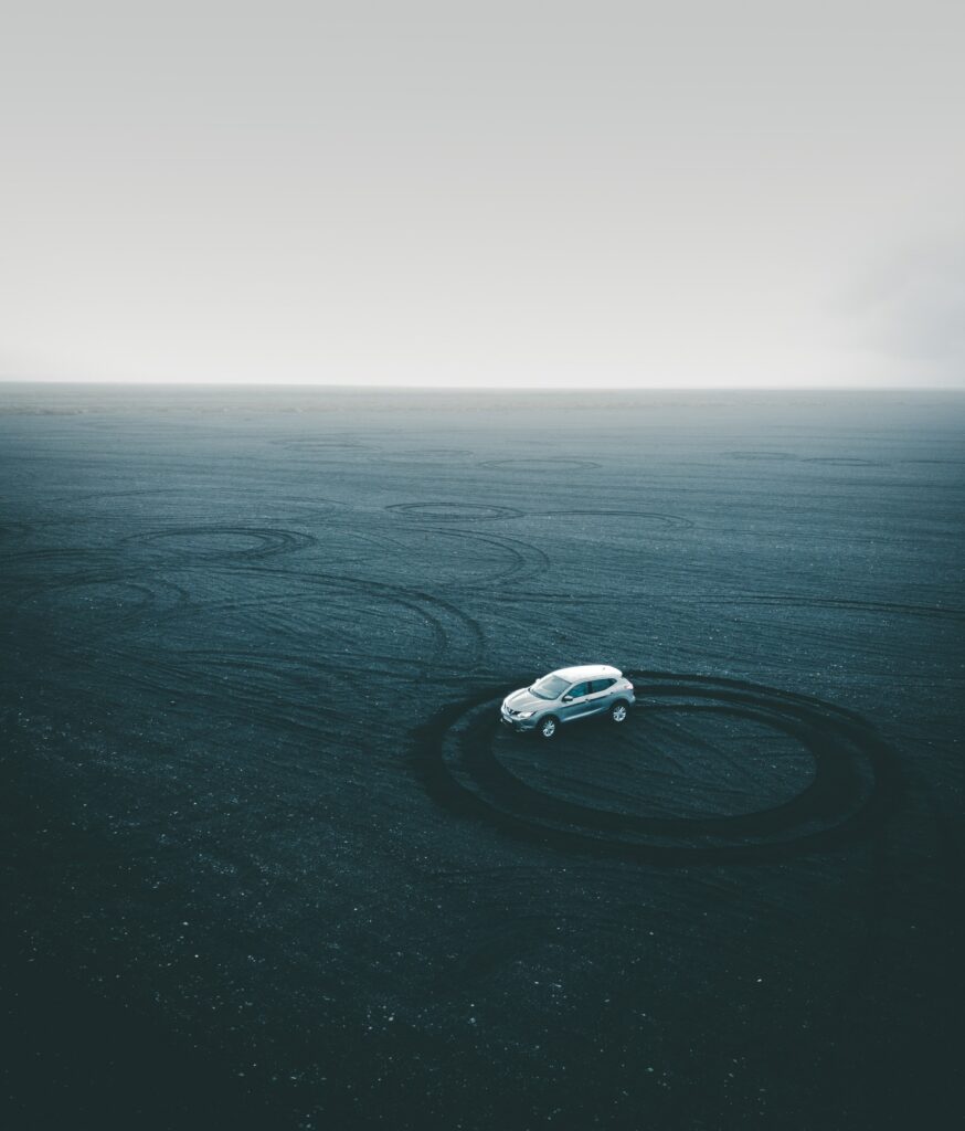 Drifting Car Wallpaper: Dynamic Tracks on Sandy Playground Background