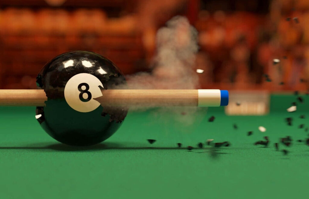 Close-up of pool cue shattering black 8-ball mid-shot on green felt pool table with motion blur Wallpaper