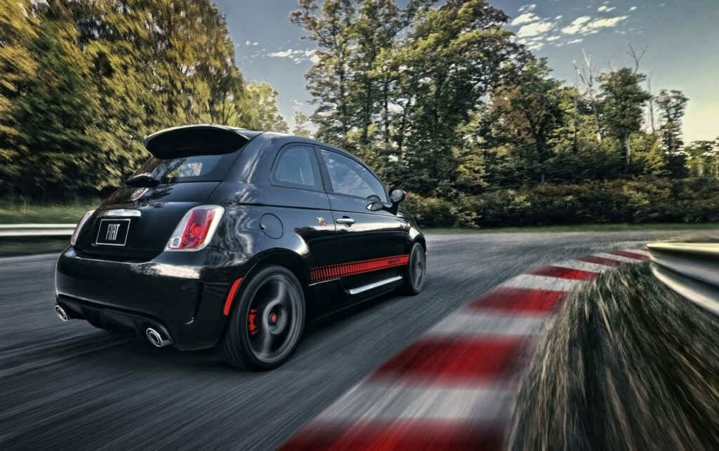 Fiat 500 Abarth in Motion: Sporty Design Amidst Lush Greenery Wallpaper