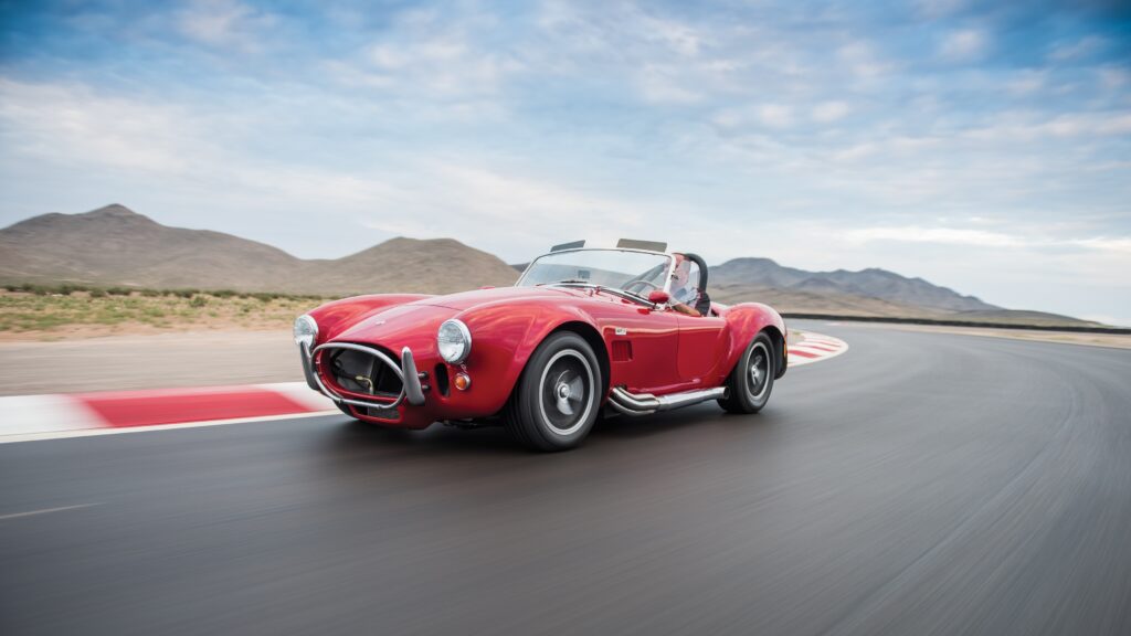 Ford Shelby Cobra 427 Racing Against Mountain Background Wallpaper