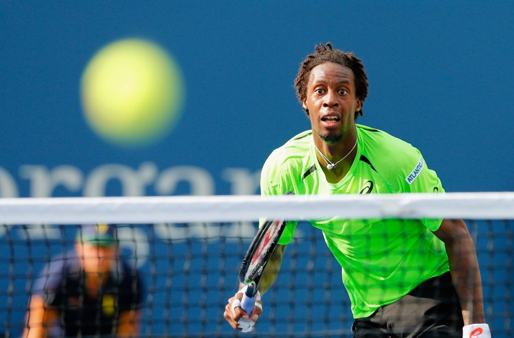 Gael Monfils tennis action shot in neon green shirt blurred ball dynamic sports wallpaper background
