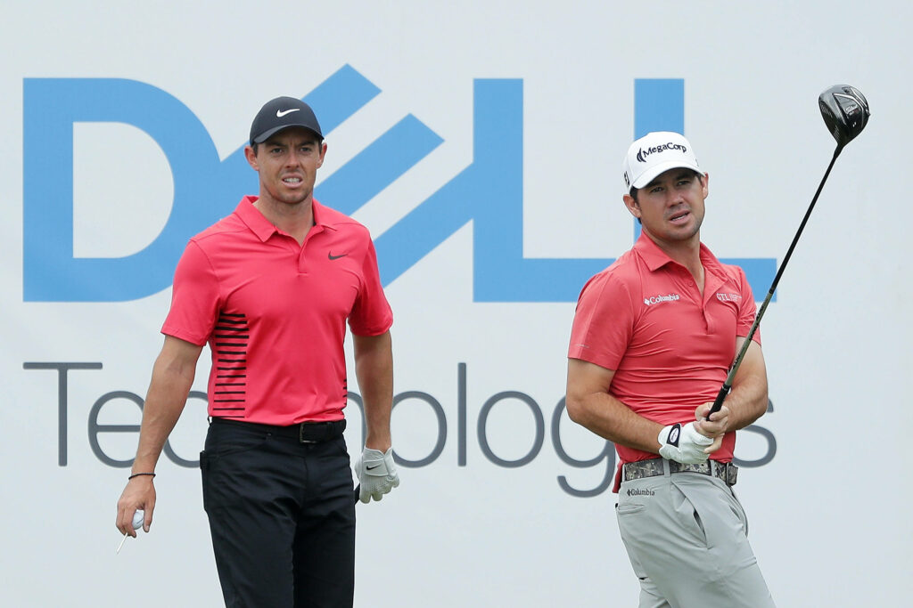 Brian Harman and Rory McIlroy in red shirts competing on golf course professional tournament background Wallpaper