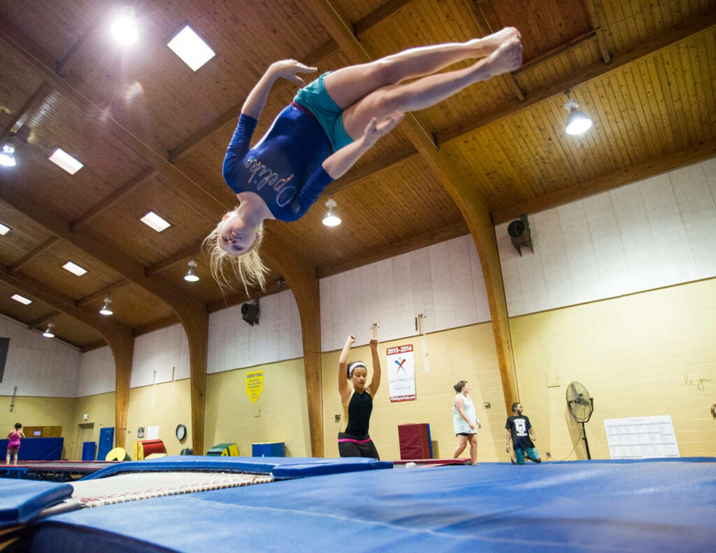 Dynamic Gymnastics Wallpaper: Athlete Tumbling on Training Floor