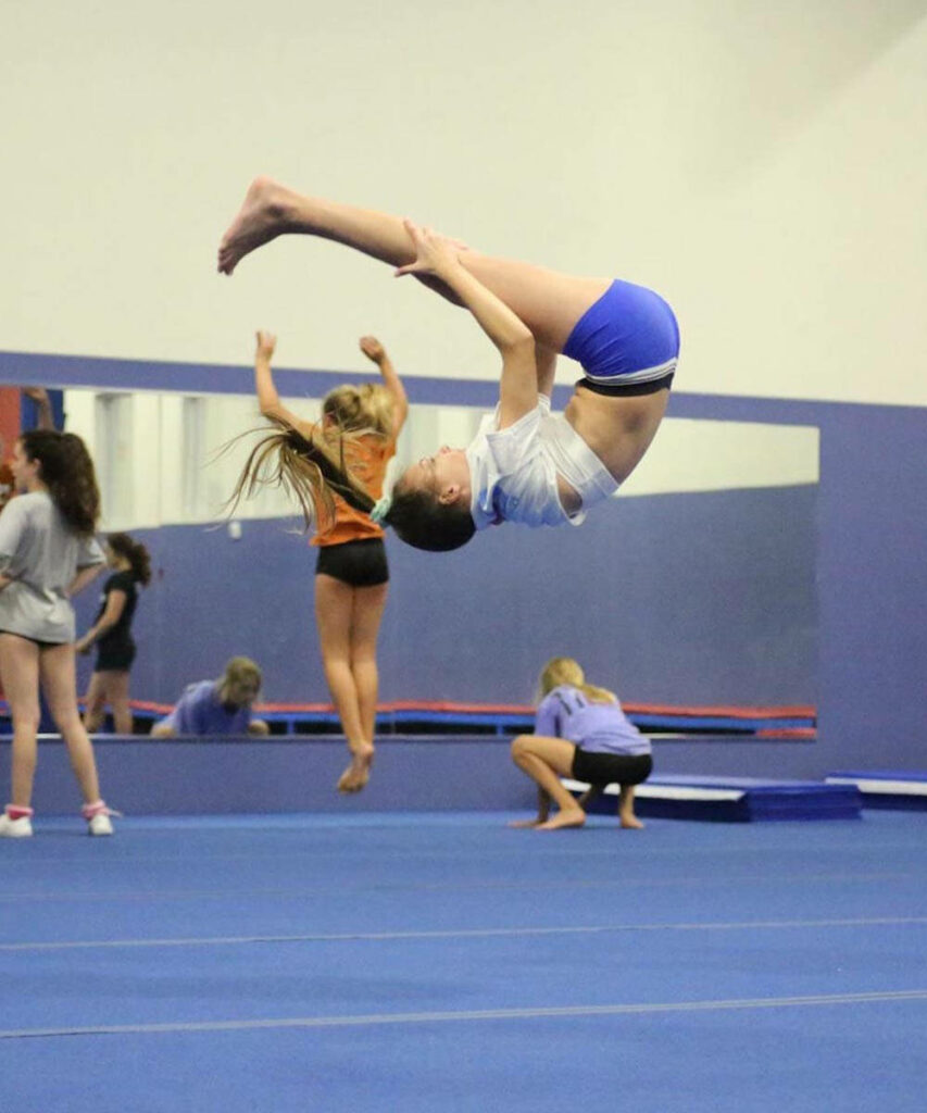 Dynamic Gymnastics Wallpaper: Athlete in Action Mid-Air Stunt