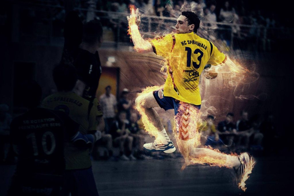 HC Spreewald handball player number 13 jumping mid-air with digital flames in indoor arena background Wallpaper