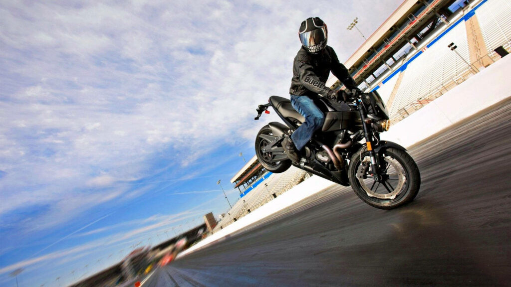 Dynamic HD Wallpaper: Matte Black Motorcycle Stunt on Expansive Track