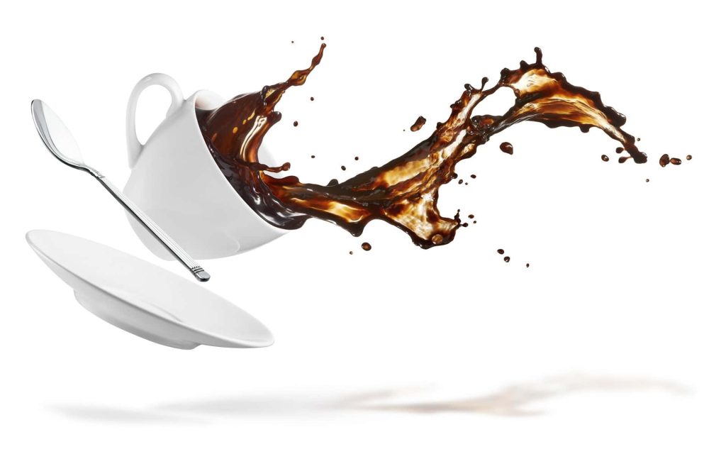White coffee cup saucer and spoon suspended in midair with dramatic splash of dark coffee liquid Wallpaper