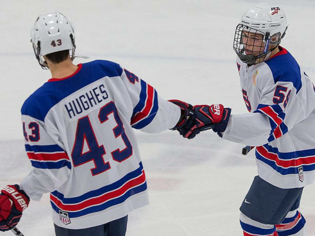 Jack Hughes Celebrates Teamwork on Ice - Hockey Wallpaper Background