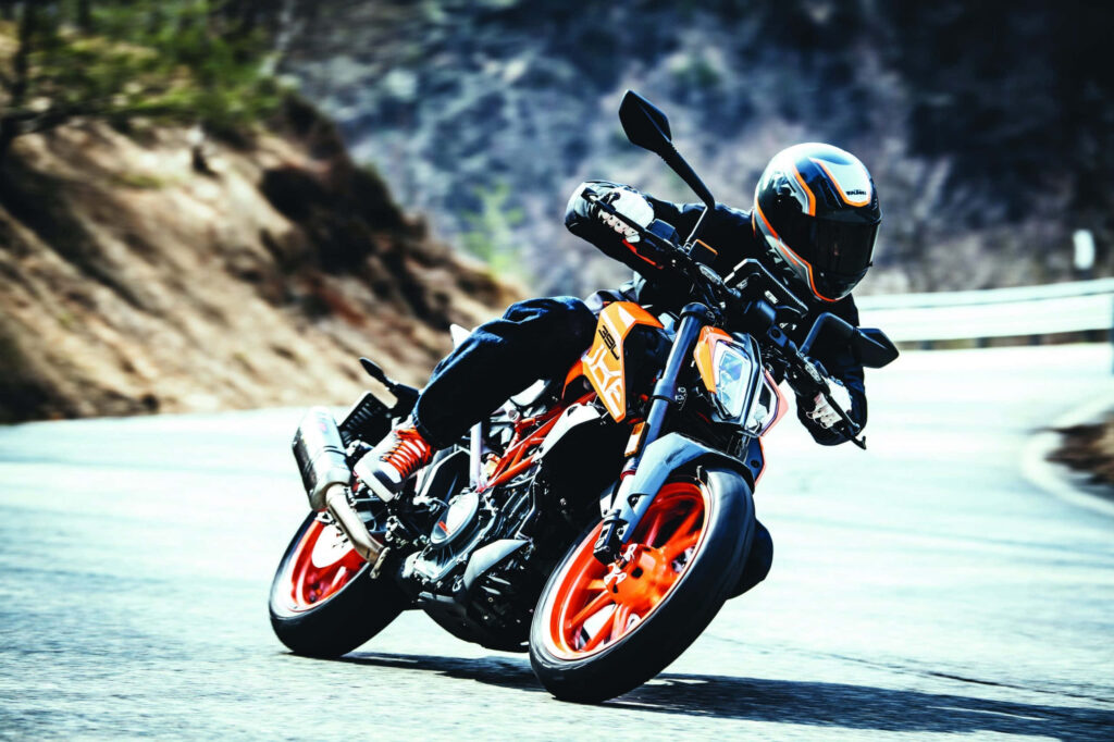 KTM Duke 390 Wallpaper: Rider Leaning into Curve on Winding Road