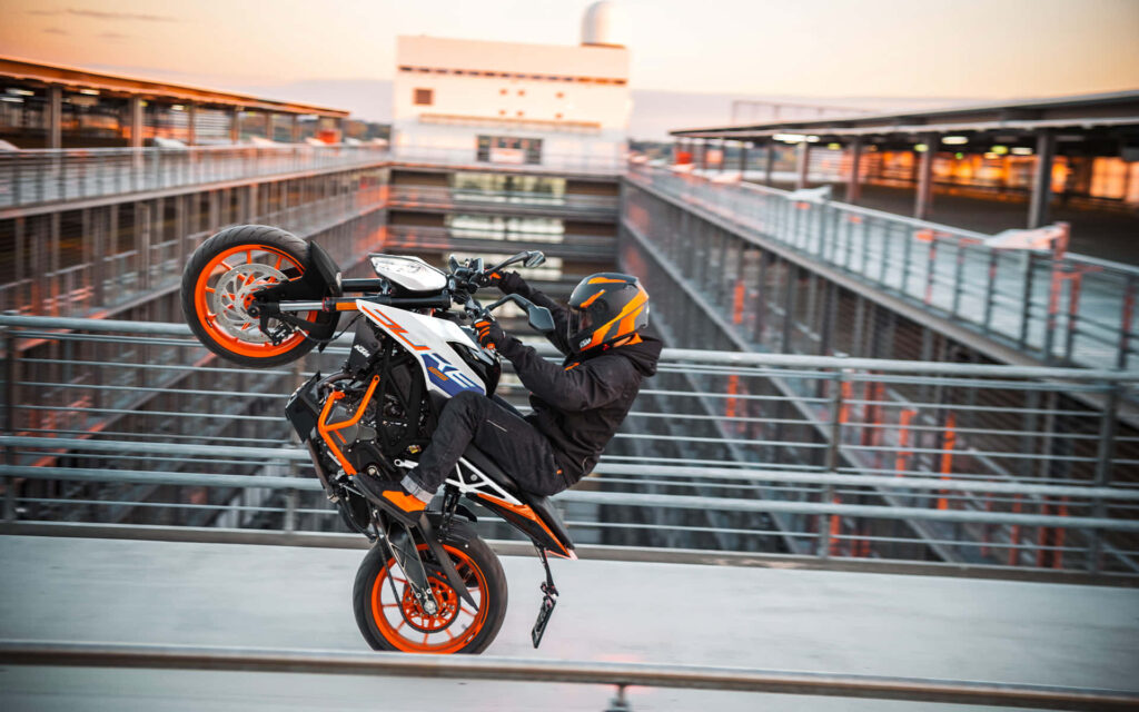 Thrilling KTM Duke Wheelie Wallpaper: Urban Adventure Background