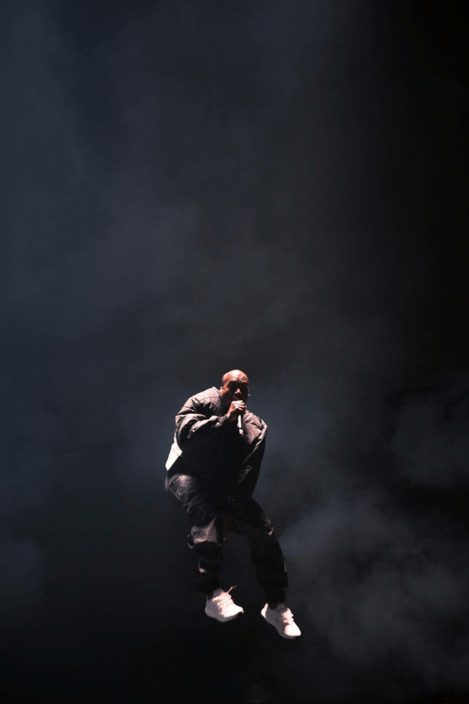 Kanye West Dynamic Stage Wallpaper: Energetic Performance Background