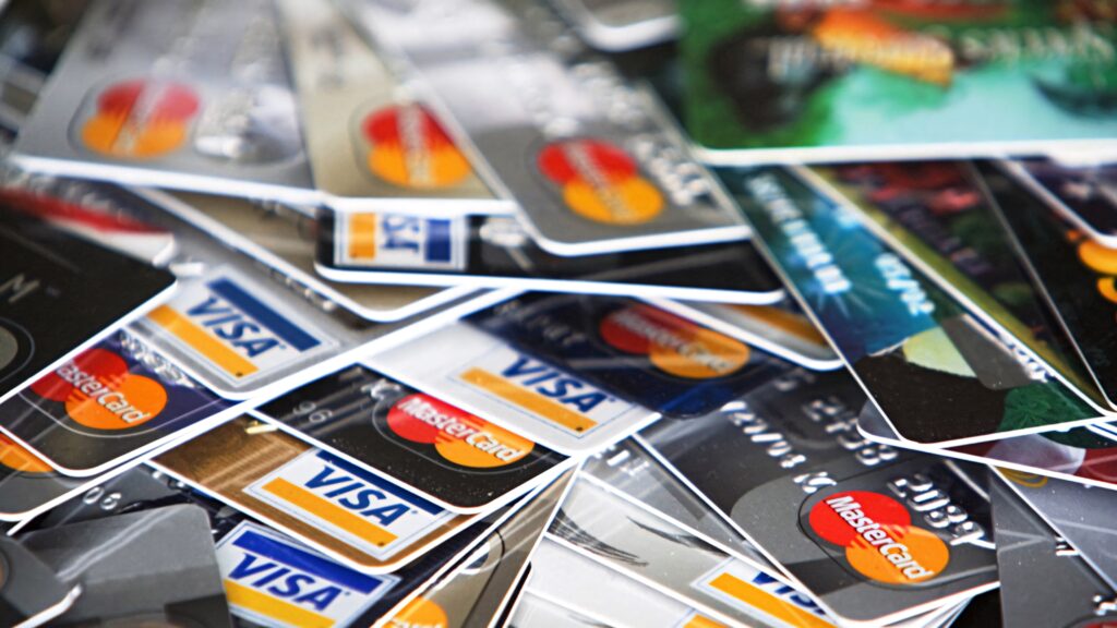 Stacked Mastercard and Visa credit cards in bold colors modern financial wallpaper background