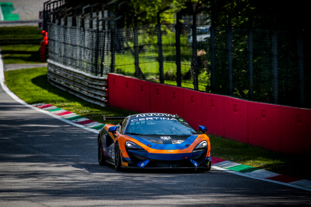 Dynamic McLaren Sports Car Racing Wallpaper - Lush Green Background